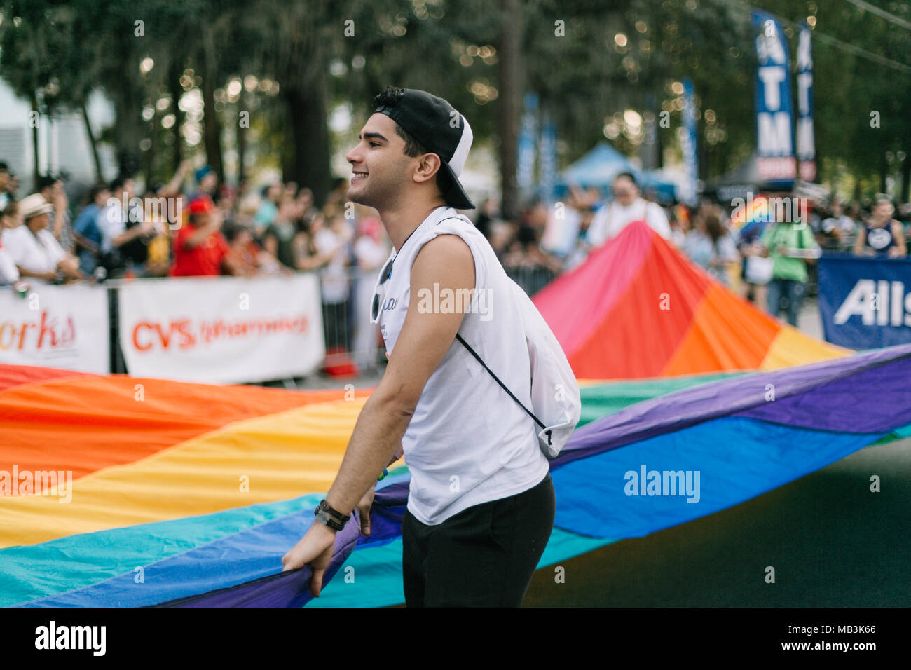 Person hält eine große Regenbogenfahne bei der Orlando Pride Parade (2016). Stockfoto