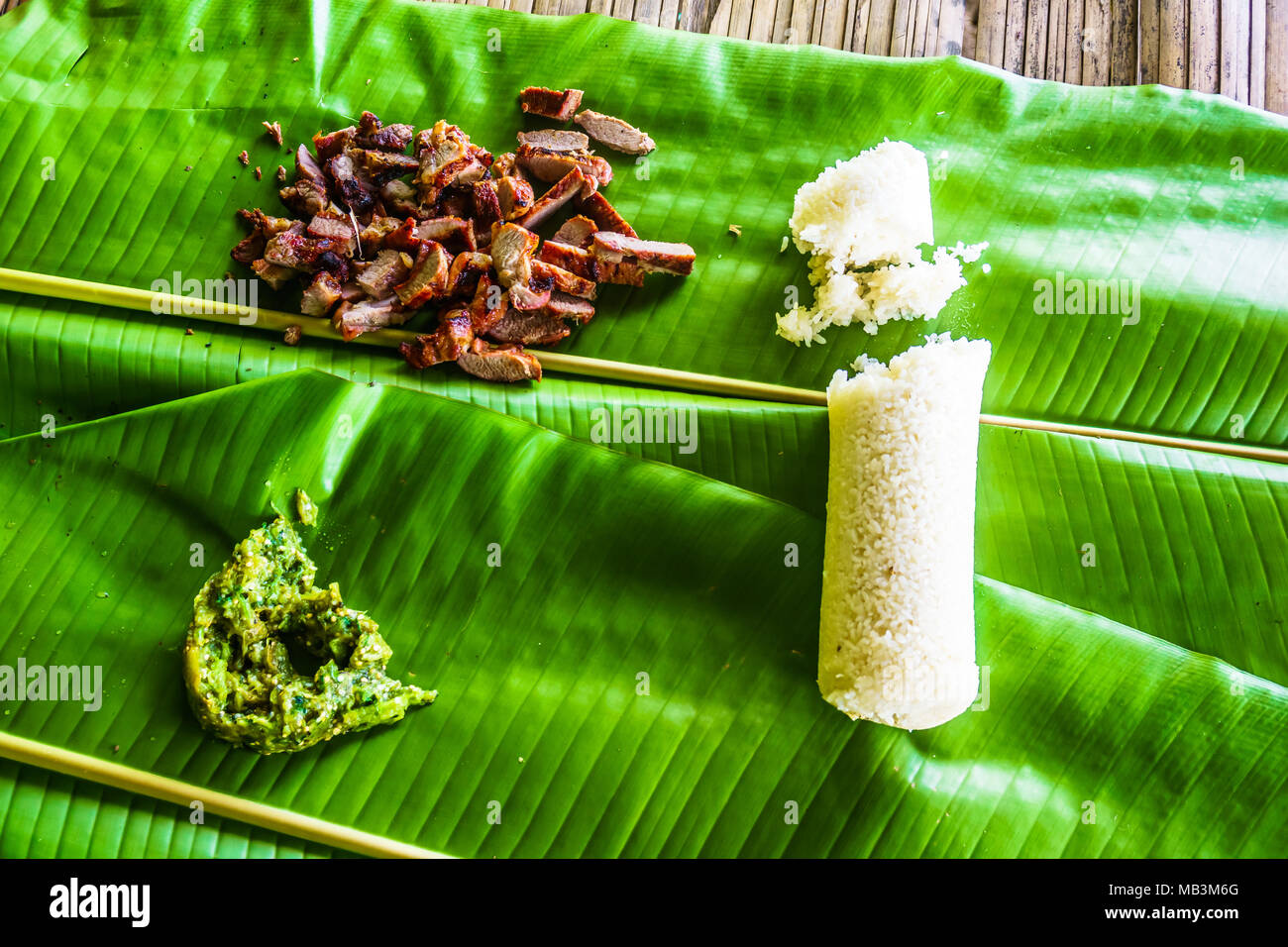 Blick auf gegrilltem Schweinefleisch und Reis Banana Leaf in Thailand Stockfoto