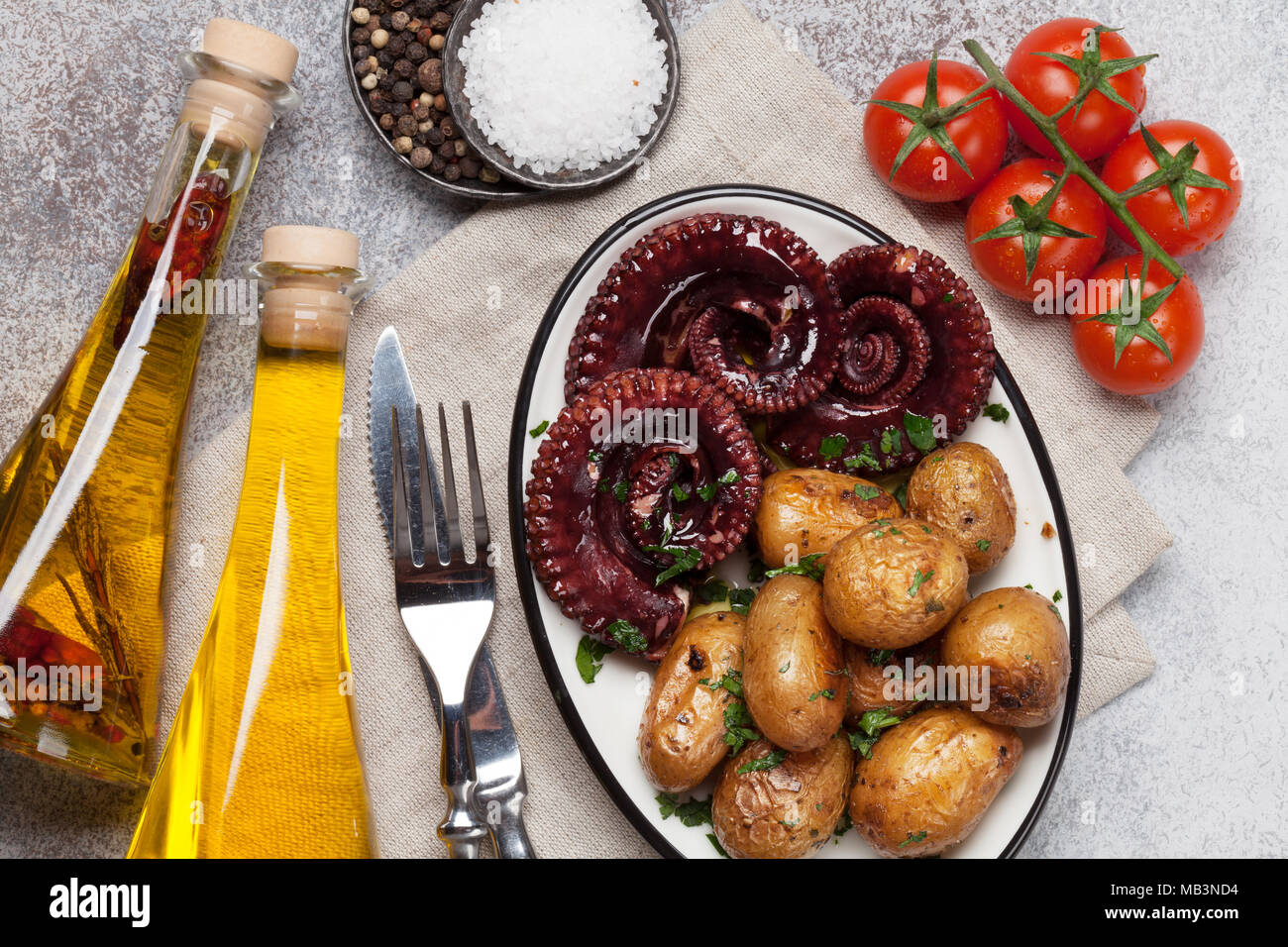 Gegrillter Tintenfisch mit kleinen Kartoffeln mit Kräutern und Gewürzen. Ansicht von oben Stockfoto