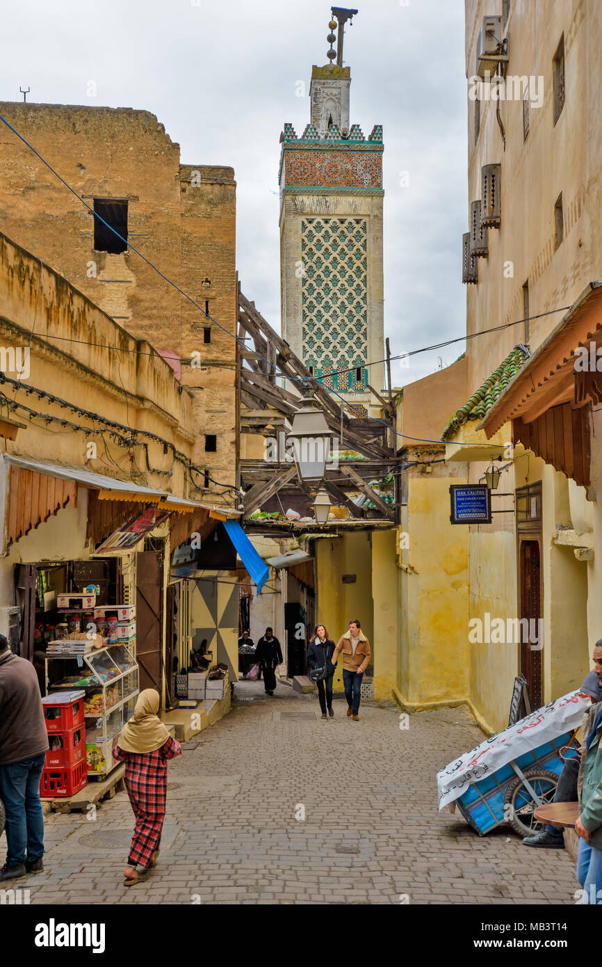 Marokko Fes Medina Souk Gasse mit Geschäften und Moschee Minarett Stockfoto