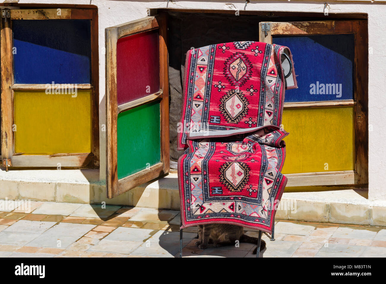 Marokko Fes Medina Souk TEPPICH AUF EINEN STUHL UND FARBIGEN FENSTERN Stockfoto