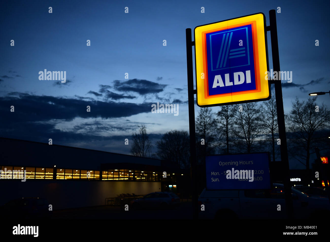 Discounter in Großbritannien: Eine beleuchtete ALDI low cost Supermarkt Store anmelden bei Nacht außerhalb einer Niederlassung der Store in Cirencester UK Stockfoto