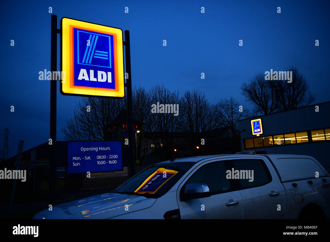 Discounter in Großbritannien: Eine beleuchtete ALDI low cost Supermarkt Store anmelden bei Nacht außerhalb einer Niederlassung der Store in Cirencester UK Stockfoto