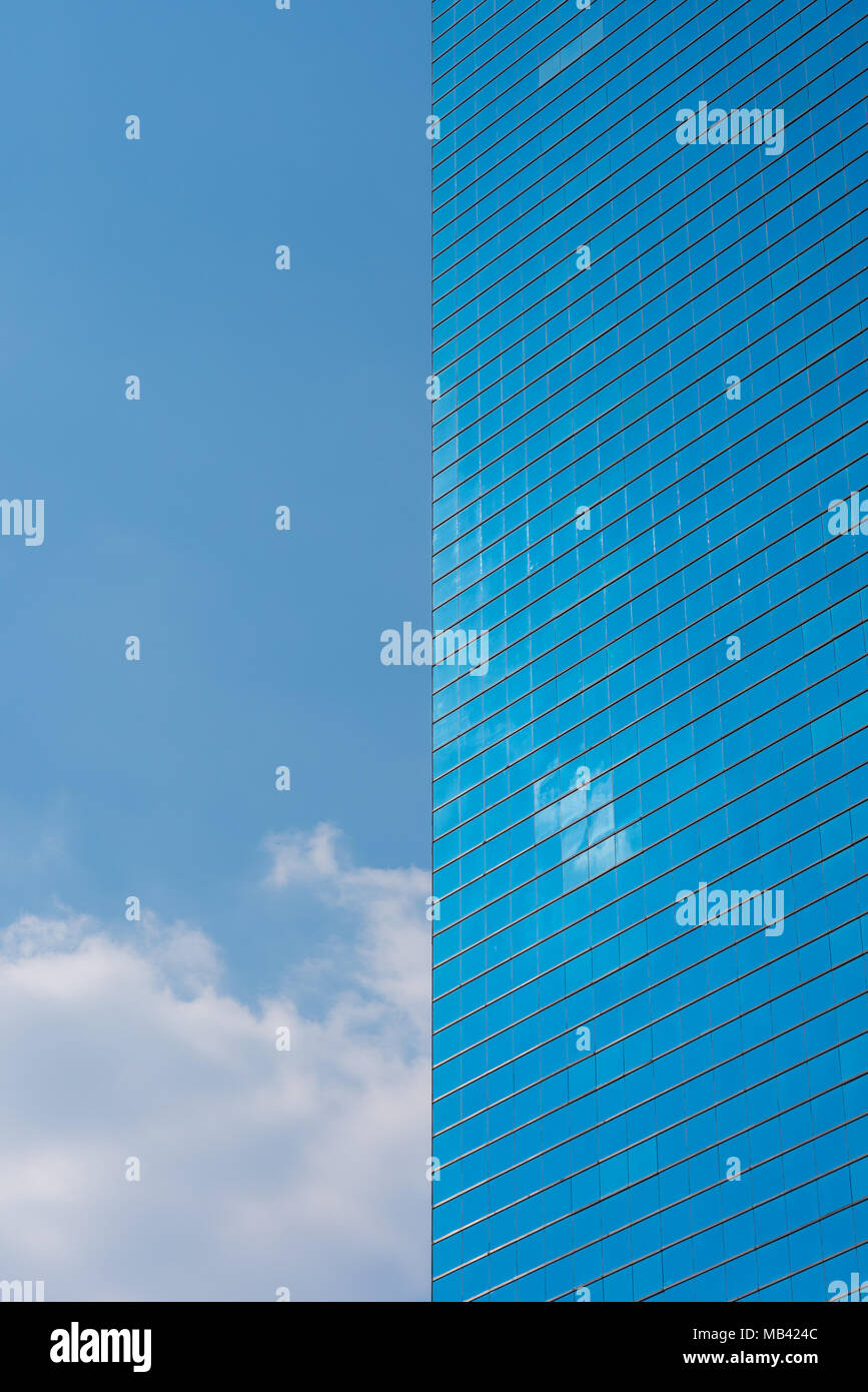 Blue office Gebäude aus Glas und blauer Himmel mit Wolken - vertikale Foto. Wolkenkratzer und den Himmel teilen das Bild in zwei symmetrische Hälften Stockfoto