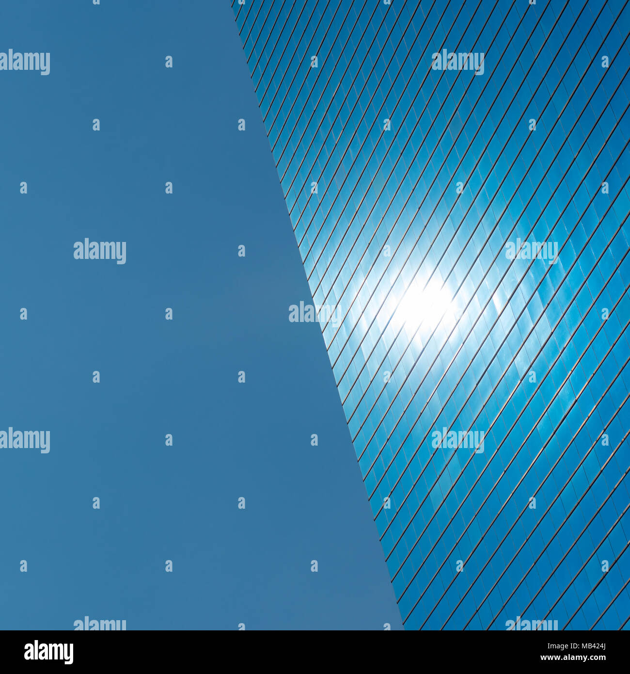Blauen Hintergrund. Die linke Seite ist blauer Himmel, der rechten Hälfte ist ein Modernes blaues Glas Bürogebäude mit einem Punkt, ist die Reflexion der Sonne Stockfoto