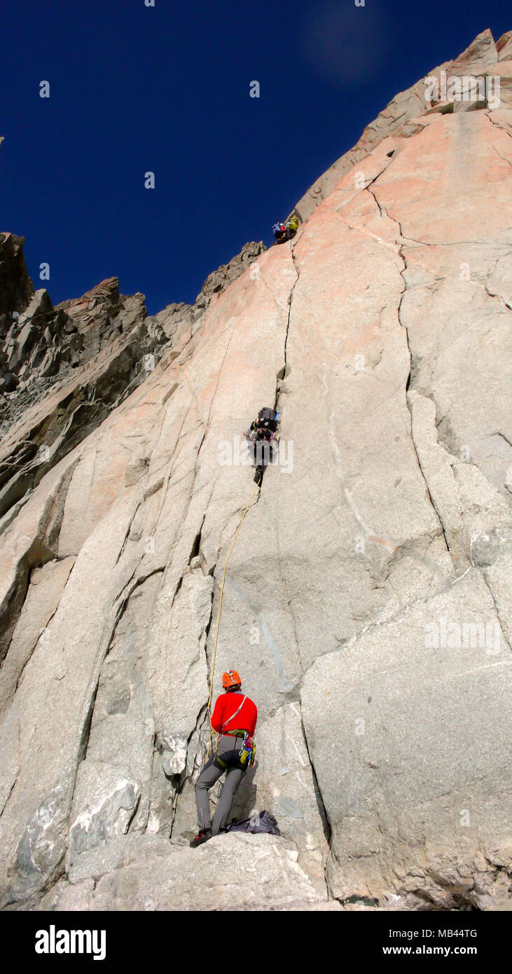 Zwei Kletterer auf einem schwierigen Weg in eine vertikale Granitwand in den Französischen Alpen unter einem blauen Himmel Stockfoto