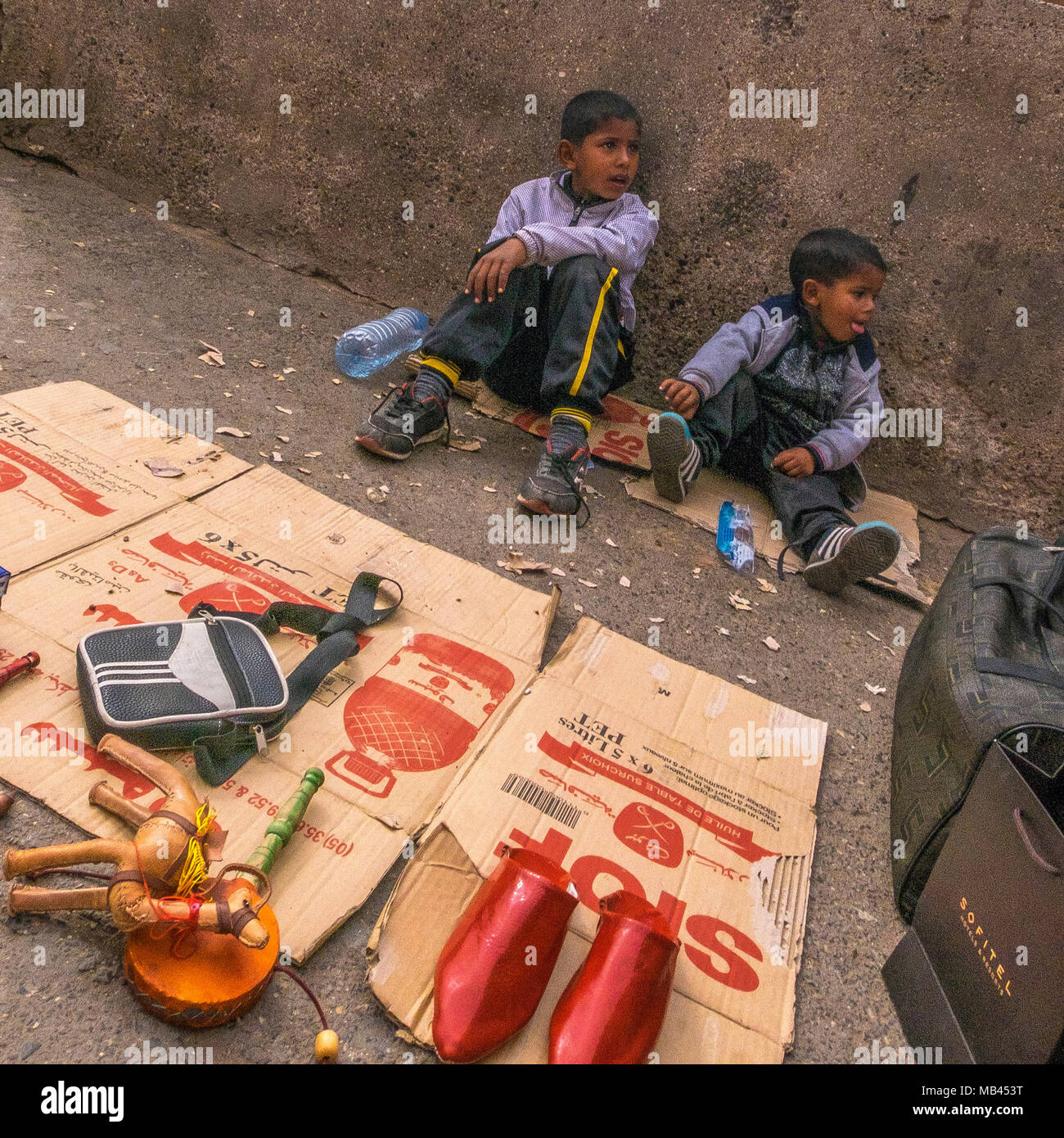 Kinder Verkauf von Artikeln auf dem Bürgersteig in den Souks von Marrakesch, Marokko Stockfoto