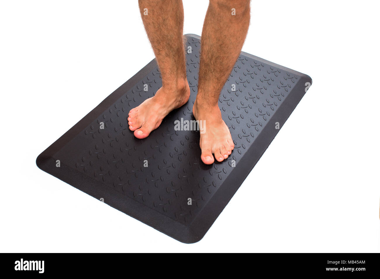 Schwarze Fußmatte mit barfuß Stehen. Stockfoto