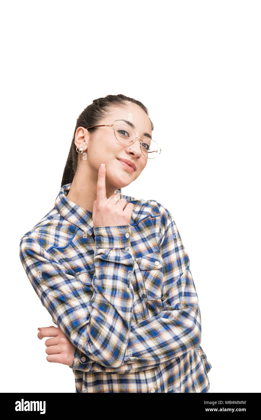 Lächelnd alternative jugendlich Mädchen mit Brillen in blaues Hemd von der Kamera mit dem Finger über die Wange suchen Stockfoto
