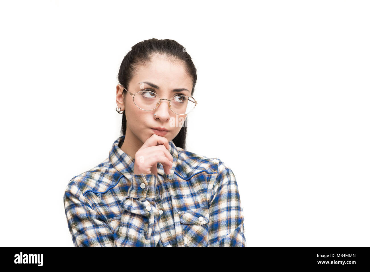 Unsichere alternative jugendlich Mädchen mit Brille im blauen Hemd sah zweifelnd Finger auf Kinn Stockfoto