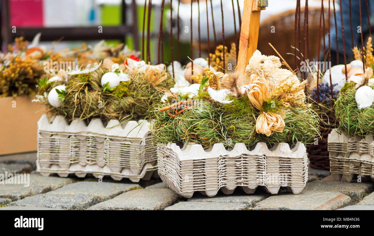 Traditionelle Osterdekorationssymbole aus natürlichen Materialien, Kaninchen, Hühnern, Henne, Strohhalm, Eiern, Ostermarkt. Stockfoto