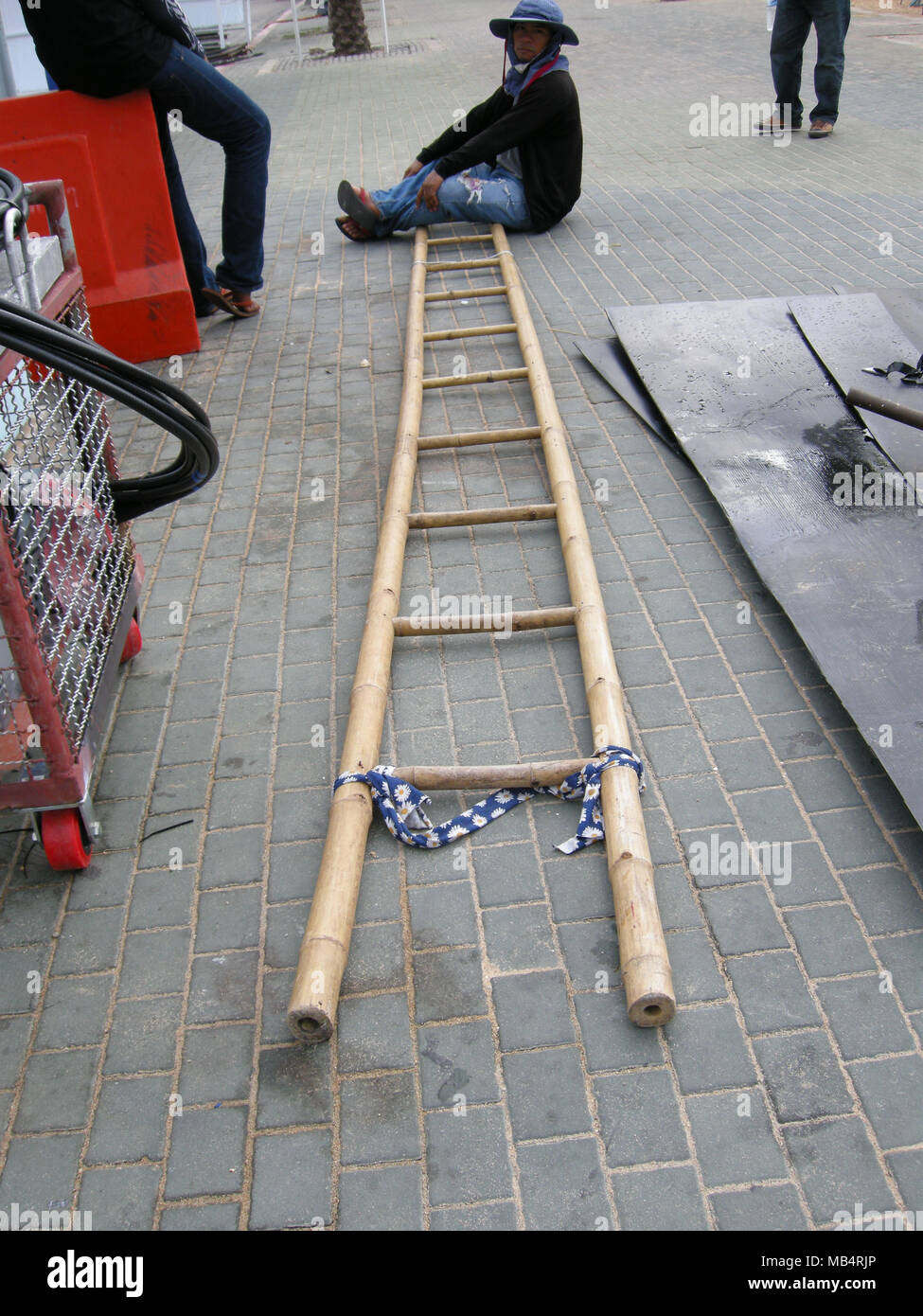 Elektriker und Techniker verwenden Sie 'isolierte' Bambus Leitern auf Freileitungen hier in Pattaya, Thailand zu arbeiten Stockfoto