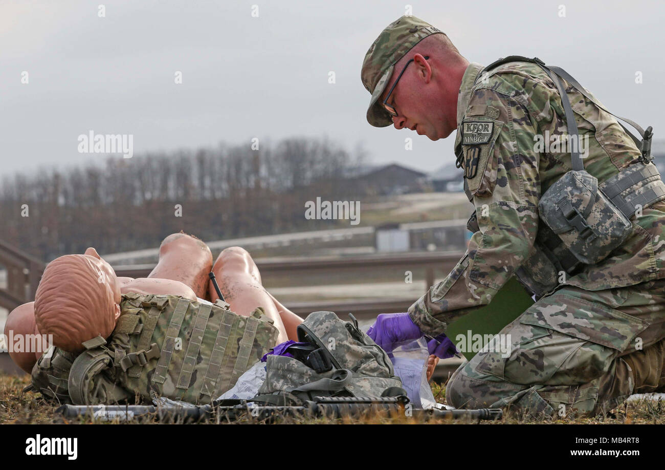 Eine MNBG - Osten NCO bietet medizinische Aufmerksamkeit zu einem Unfall während der TAKTISCHES Unfallversicherung Care Teil des NCO/Soldat der Rotation Wettbewerb im Camp Bondsteel, Kosovo, Jan. 15, 2018. Stockfoto