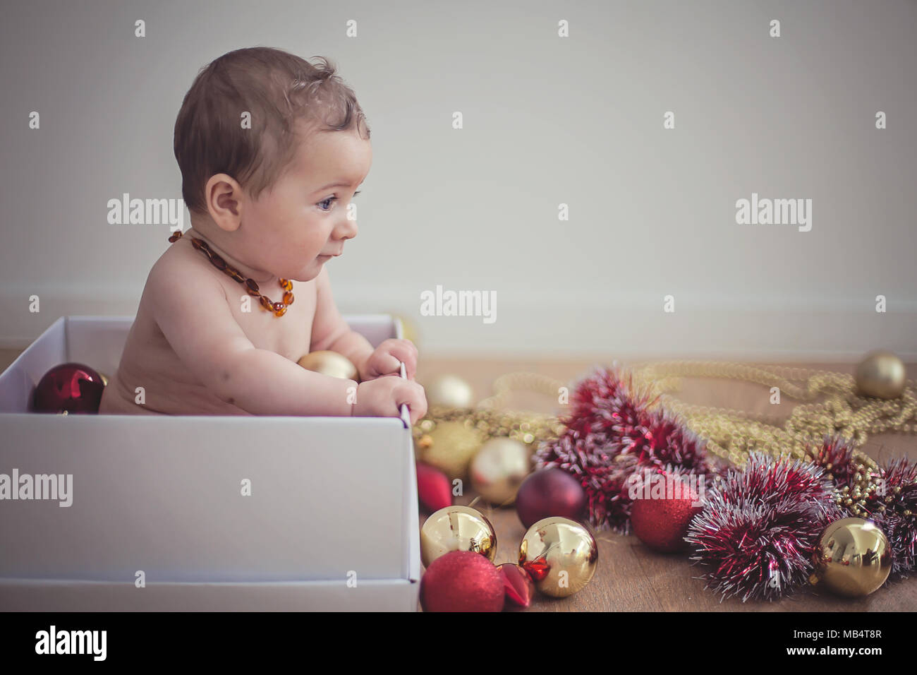6 Monate altes Baby in einer Box mit Weihnachtsschmuck Stockfoto