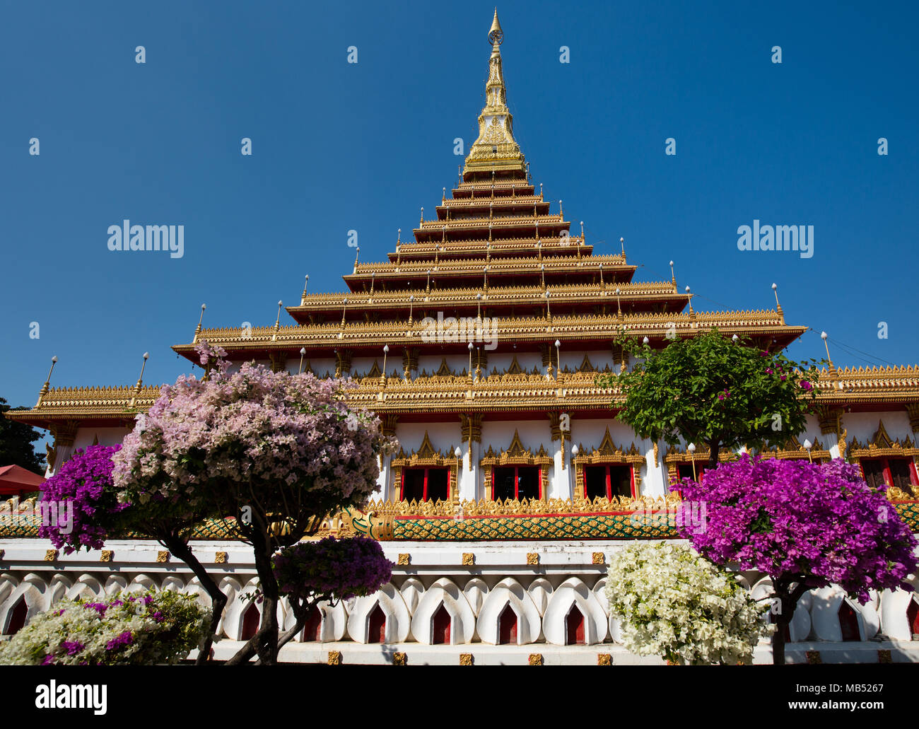 Blühende Büsche vor 9-stöckige stupa Phra Mahathat Kaen Kakhon, Wat Nong Waeng Tempel, Khon Kaen, Isan, Thailand Stockfoto