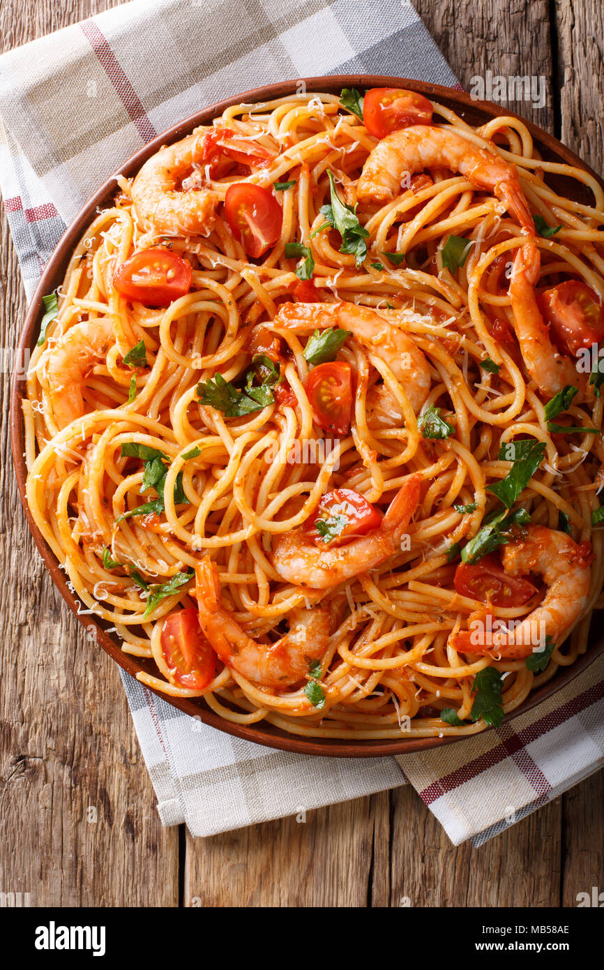 Italienische Pasta Spaghetti mit Garnelen, Parmesan und Kräuter in Tomaten Sauce diavolo Close-up auf einem Teller. Vertikal oben Ansicht von oben Stockfoto