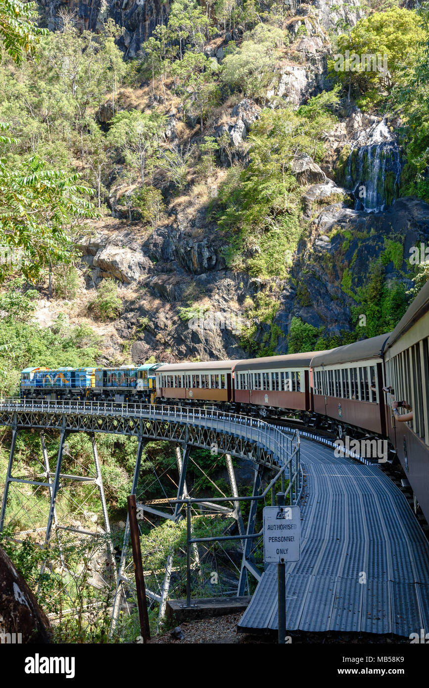 Die Kuranda Scenic Railway, wie es Köpfe zurück nach Cairns auf der Brücke durch einen Wasserfall Stockfoto