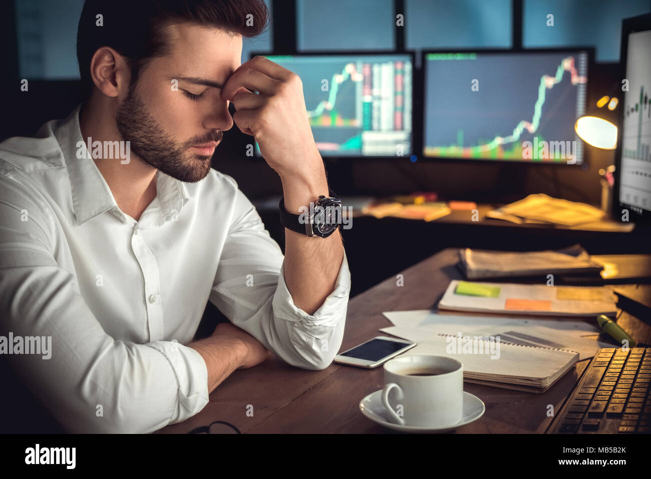 Junger bärtiger Mann Händler im Büro am Tisch sitzen geschlossenen Augen müde, Kopfschmerzen close-up Stockfoto