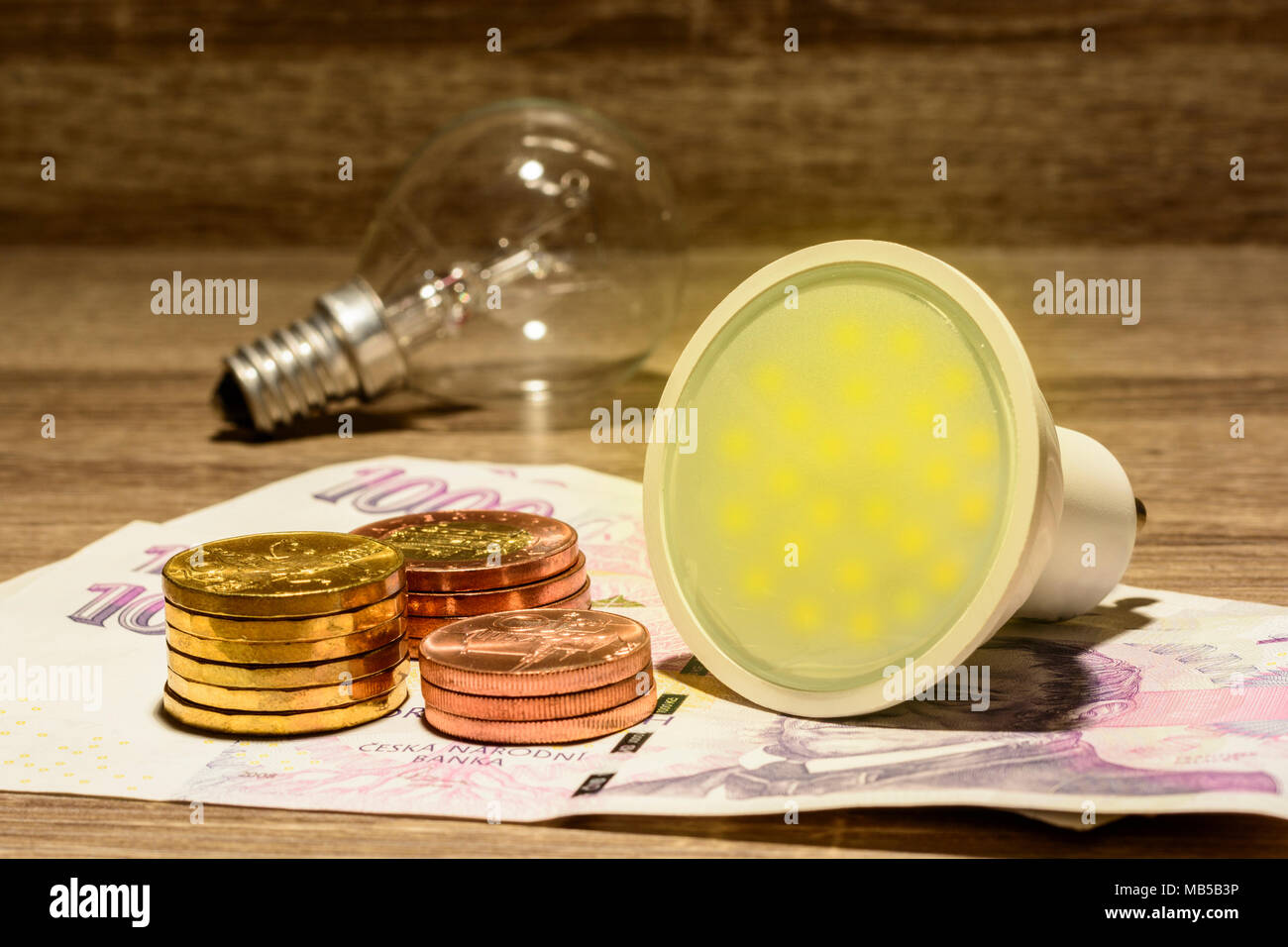 Europäische LED-Lampe leuchtet auf tschechische Geld platziert. Moderne Energie gespart. Das Konzept der Strom gespart. Die Idee, Geld und Energie zu sparen. Finanzielle Zusammenarbeit Stockfoto
