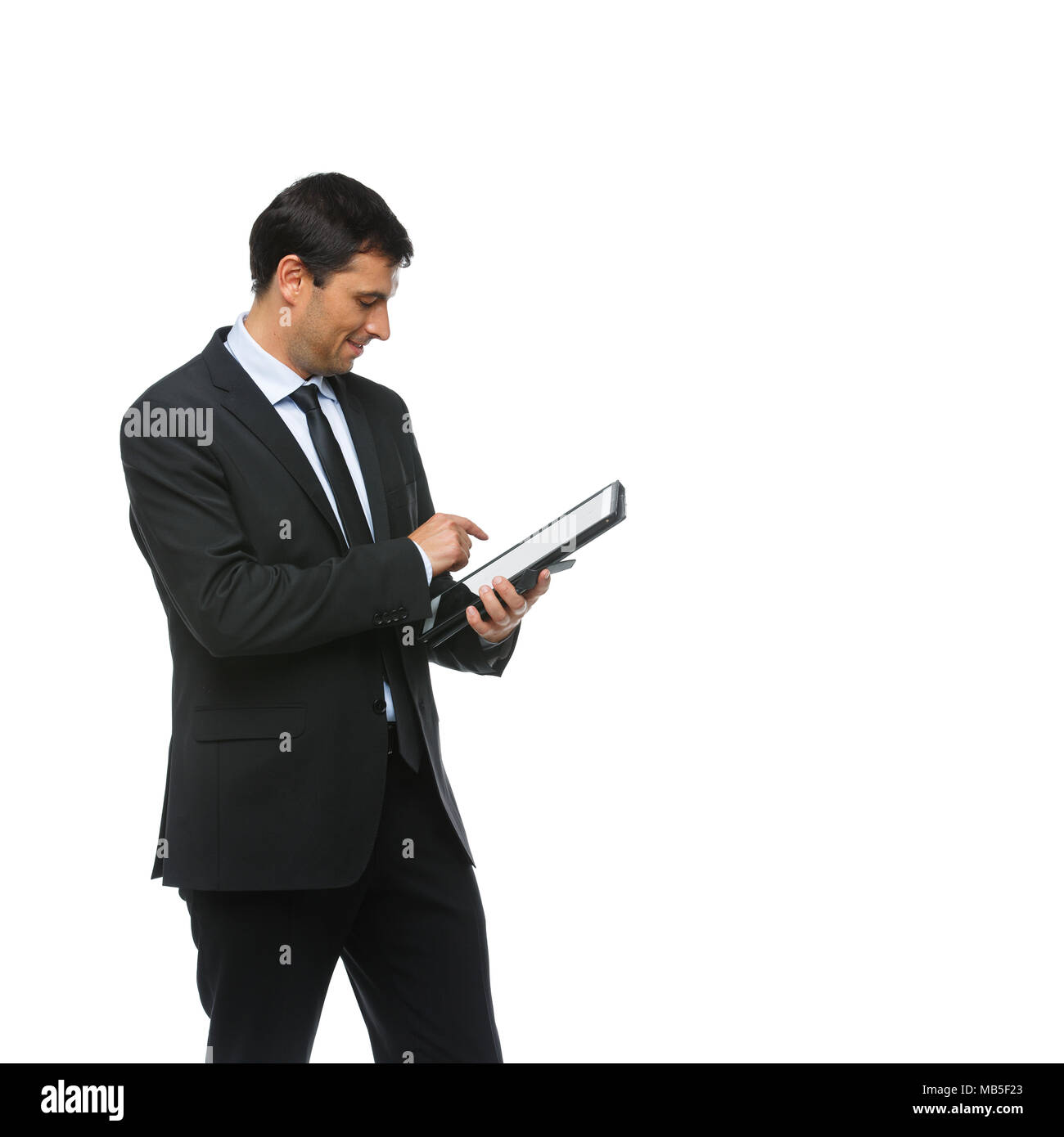 Hübscher junger Geschäftsmann in Business sut, blaues Hemd und Krawatte holding Tablet in Ledertasche. glücklichen Ausdruck. Jemand Gruß. Studio shot iso Stockfoto