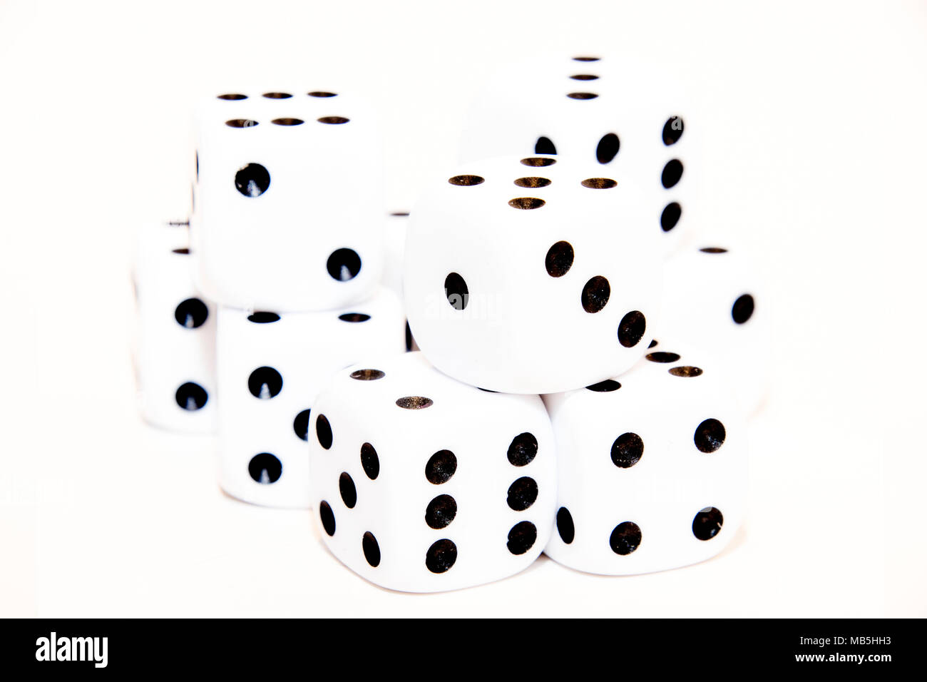 High Key Würfel Haufen auf zufällige weiße Würfel Gesichter auf einem weißen Hintergrund Stockfoto