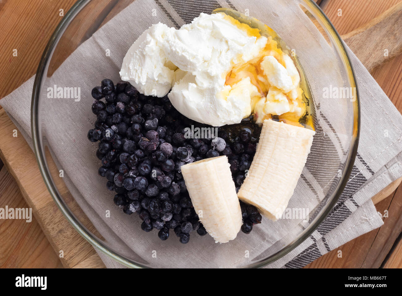 Gefrorene Heidelbeeren, Hüttenkäse, Banane und Honig - Zutaten für die Zubereitung von hausgemachten Blueberry ice cream Stockfoto