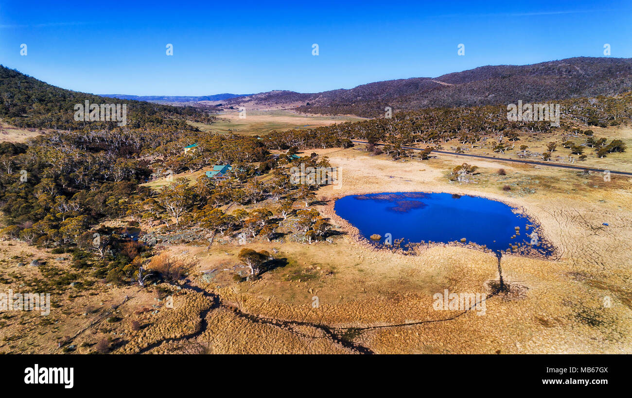 Flache Feuchtgebiet mit flachen Teich mit frischem Wasser und blauem Himmel in der Nähe der abgelegenen Farm in Perisher Valley von SNowy Mountains Region gefüllt an einem sonnigen Winter da Stockfoto