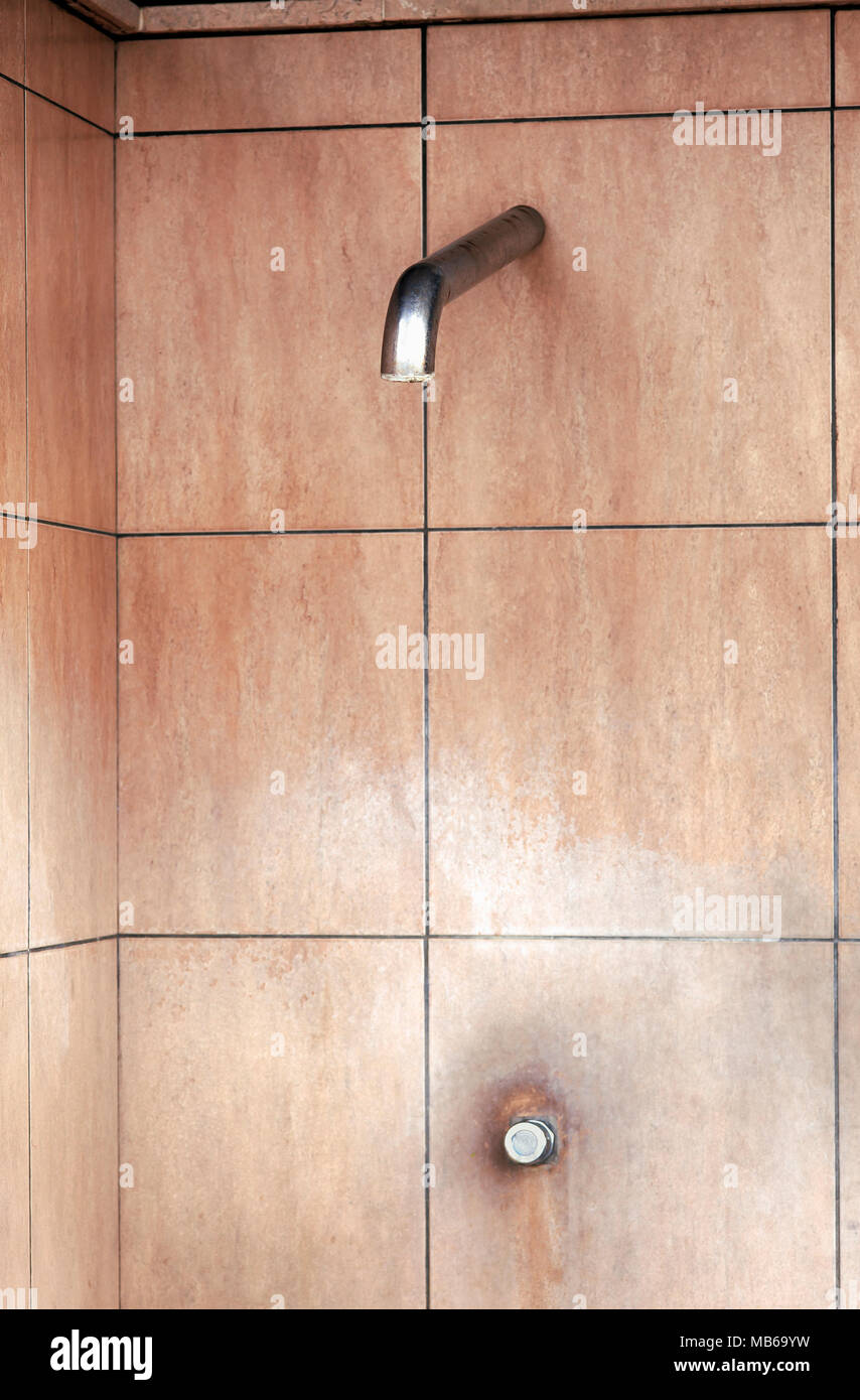 Öffentliche Dusche mit Druckknopf und Wandfliesen. Stockfoto