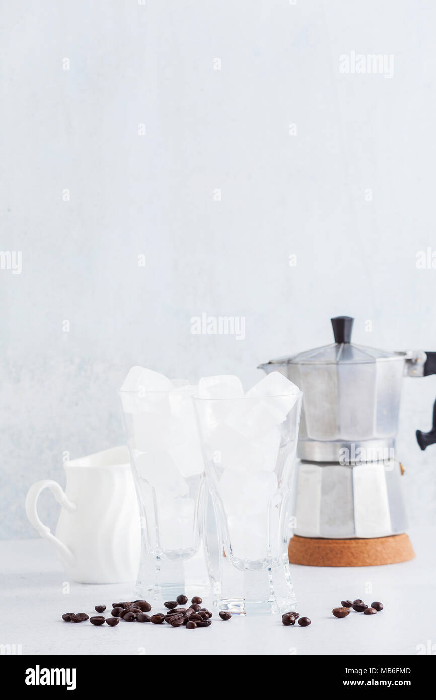 Zwei leere Gläser aus Eis auf dem Tisch. Und eine Kaffeemaschine im Hintergrund. Reine Zusammensetzung Stockfoto