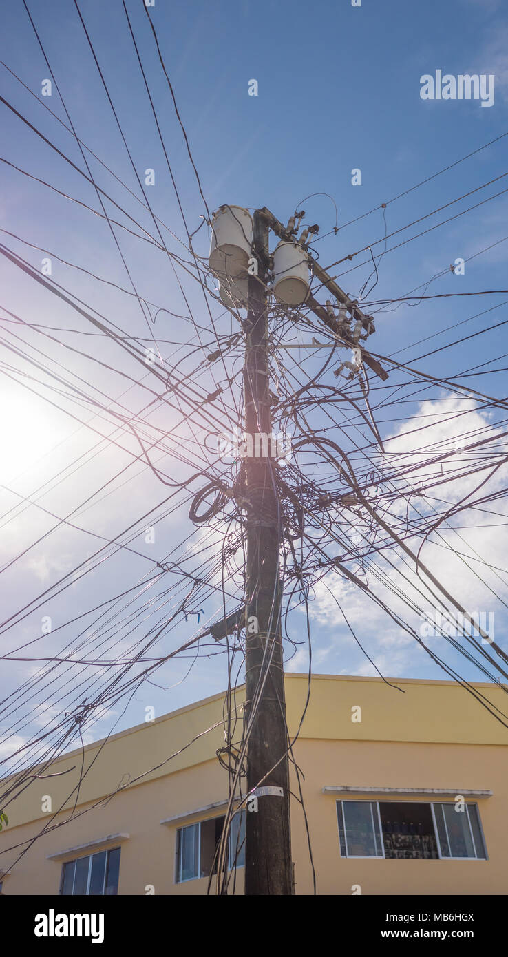 Stromleitungen in der Stadt. Transformatoren und Telefonleitungen gegen den strahlend blauen Himmel. Stockfoto