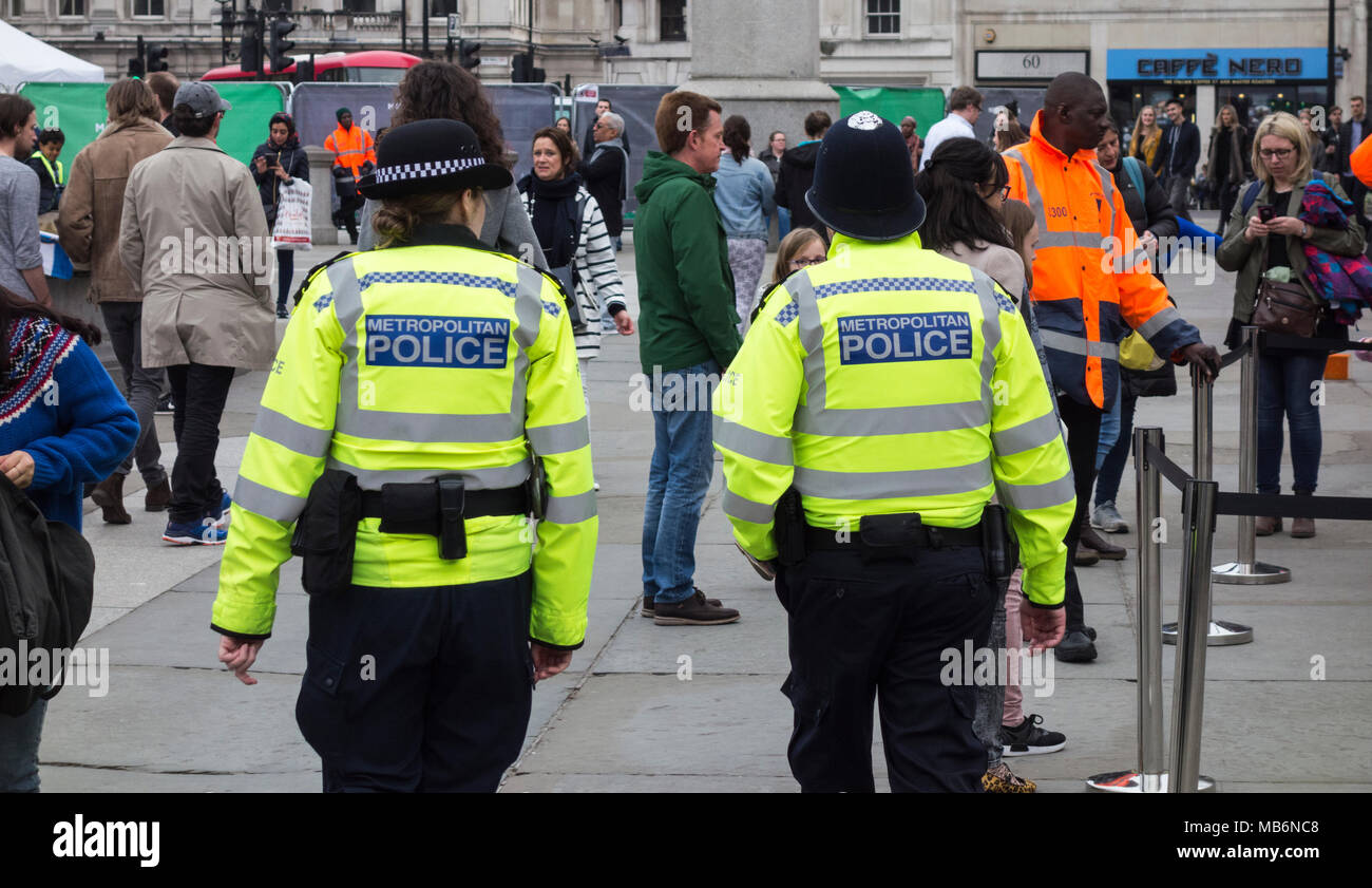 Ein Polizist und eine Polizistin (Bobbies) auf dem Beat am Trafalgar Square im Zentrum von London, England, Großbritannien Stockfoto