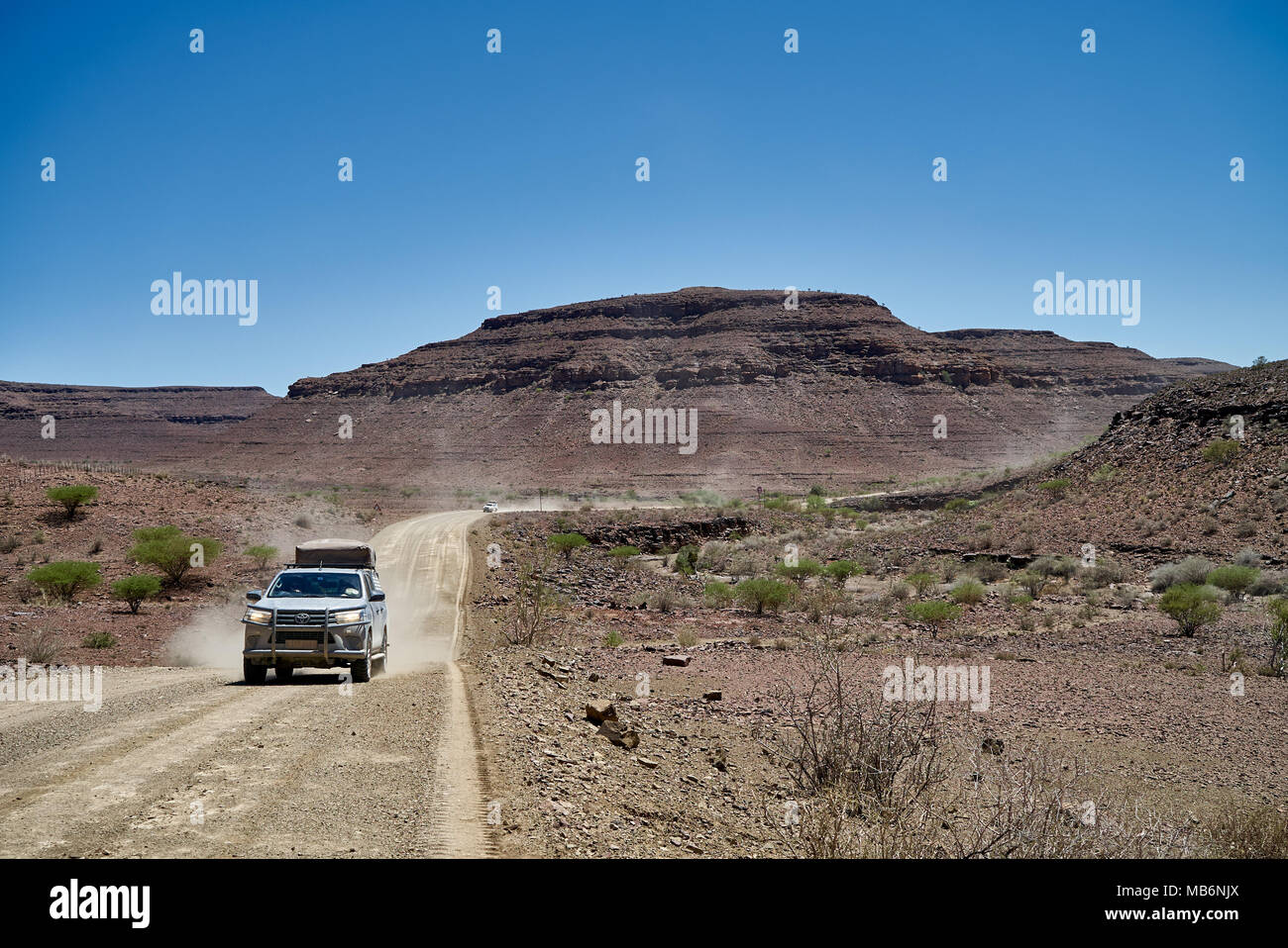 Touristen im 4x4 Autos auf einen Selbstfahrer Reise auf Schotter Straße durch einsame Felsen Berglandschaft im Süden von Namibia, Afrika Stockfoto