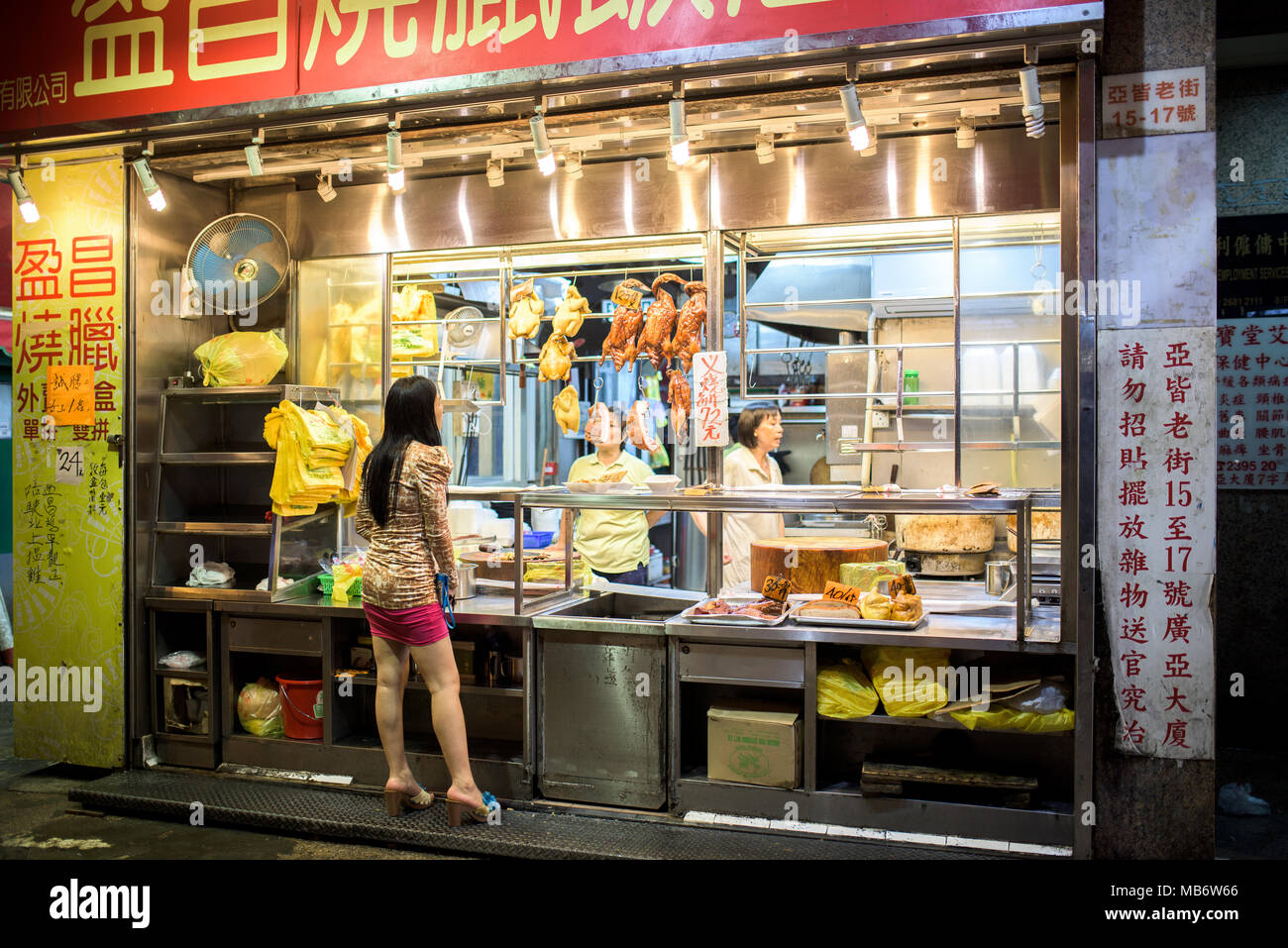 Chinesische Frau vor dem Essen Shop in den Straßen von Hong Kong Stockfoto