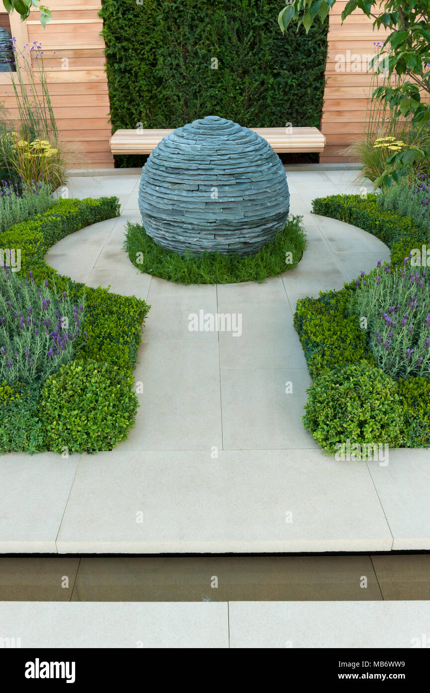 Ursprünglichen kugelförmigen Stein Mittelstück Skulptur, Pfad & Heilpflanzen - "Die Ruhe" Garten, RHS Flower Show, Tatton Park, England, UK. Stockfoto