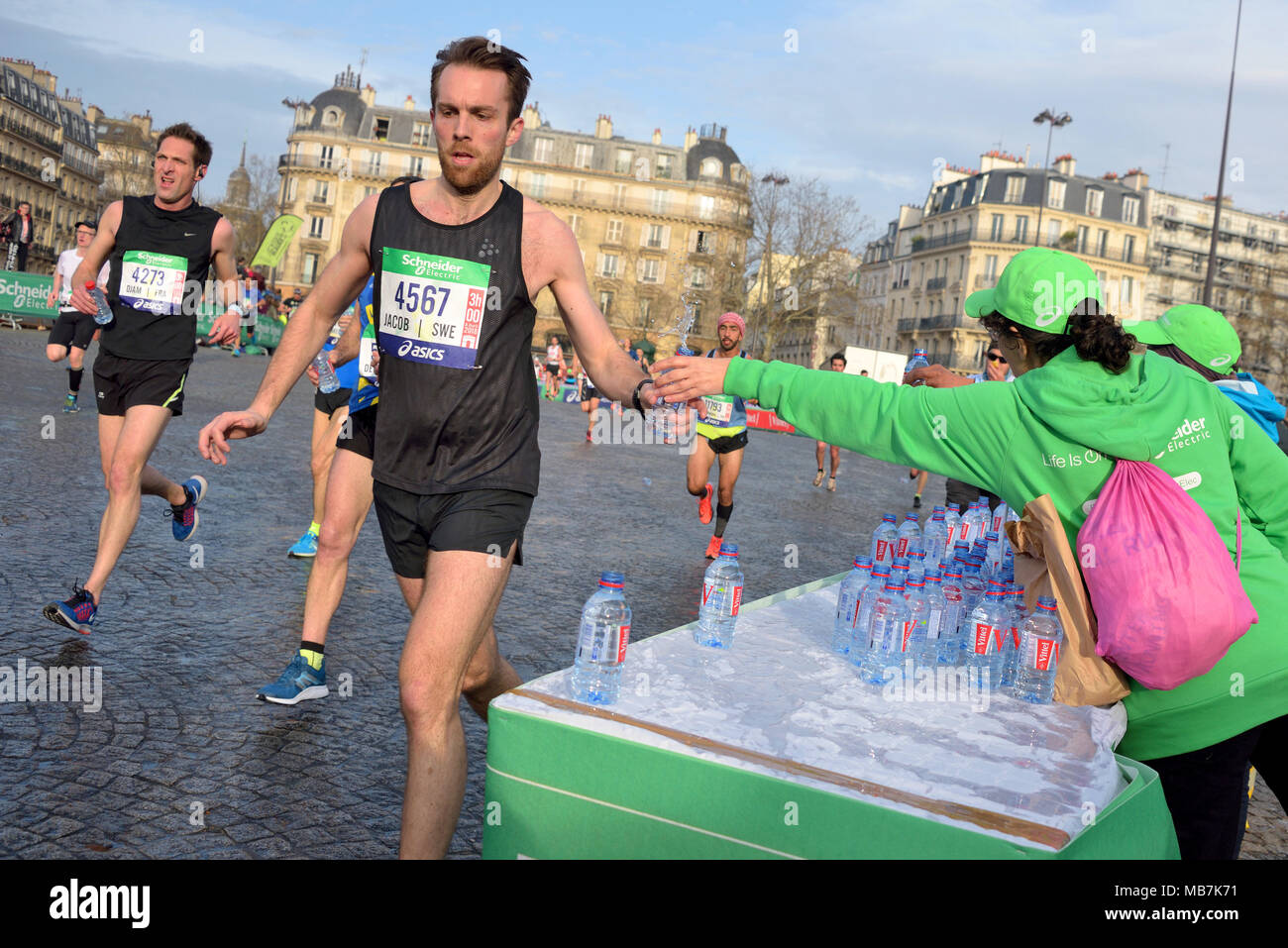 Paris, Frankreich. 8 Apr, 2018. Ein Läufer gesehen Zugriffen Dritter eine Flasche Wasser während der 42. Ausgabe des "'˜ Paris Marathon 2018". Paul Lonyangata aus Kenia gewann den Paris Marathon für die Gruppe der Männer mit einer offiziellen Zeit von 2 Stunden, 6 Minuten, 25 Sekunden, und Betsy Saina aus Kenia gewann für die Gruppe der Frauen mit einem offiziellen Zeit von 2 Stunden, 22 Minuten, 56 Sekunden. Credit: Nicolas Briketts/SOPA Images/ZUMA Draht/Alamy leben Nachrichten Stockfoto