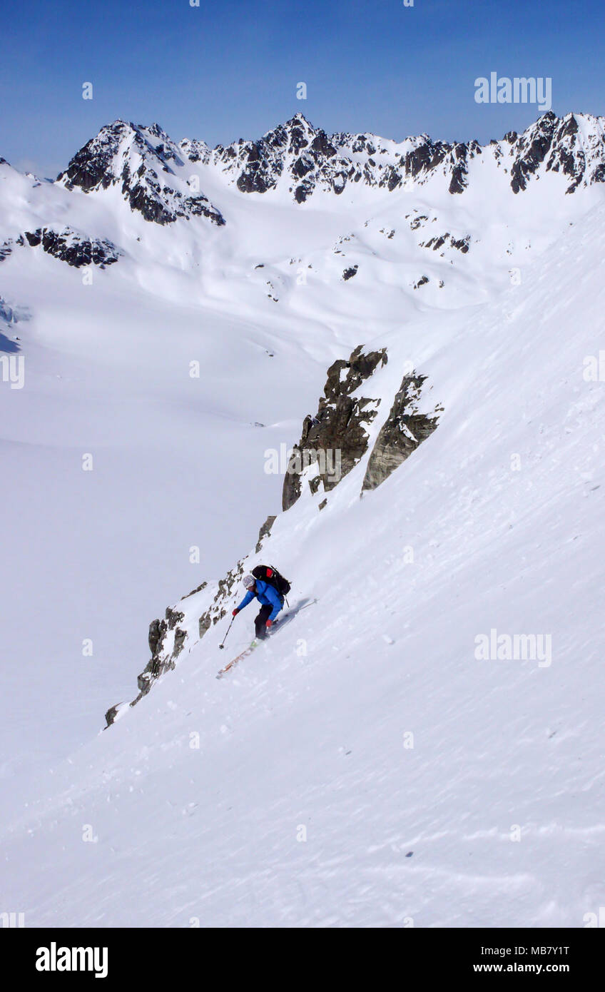 Männliche extreme Skifahrer Skifahren nach unten eine sehr steile Rinne im tiefen Winter in den Schweizer Alpen in der Nähe von Klosters Stockfoto