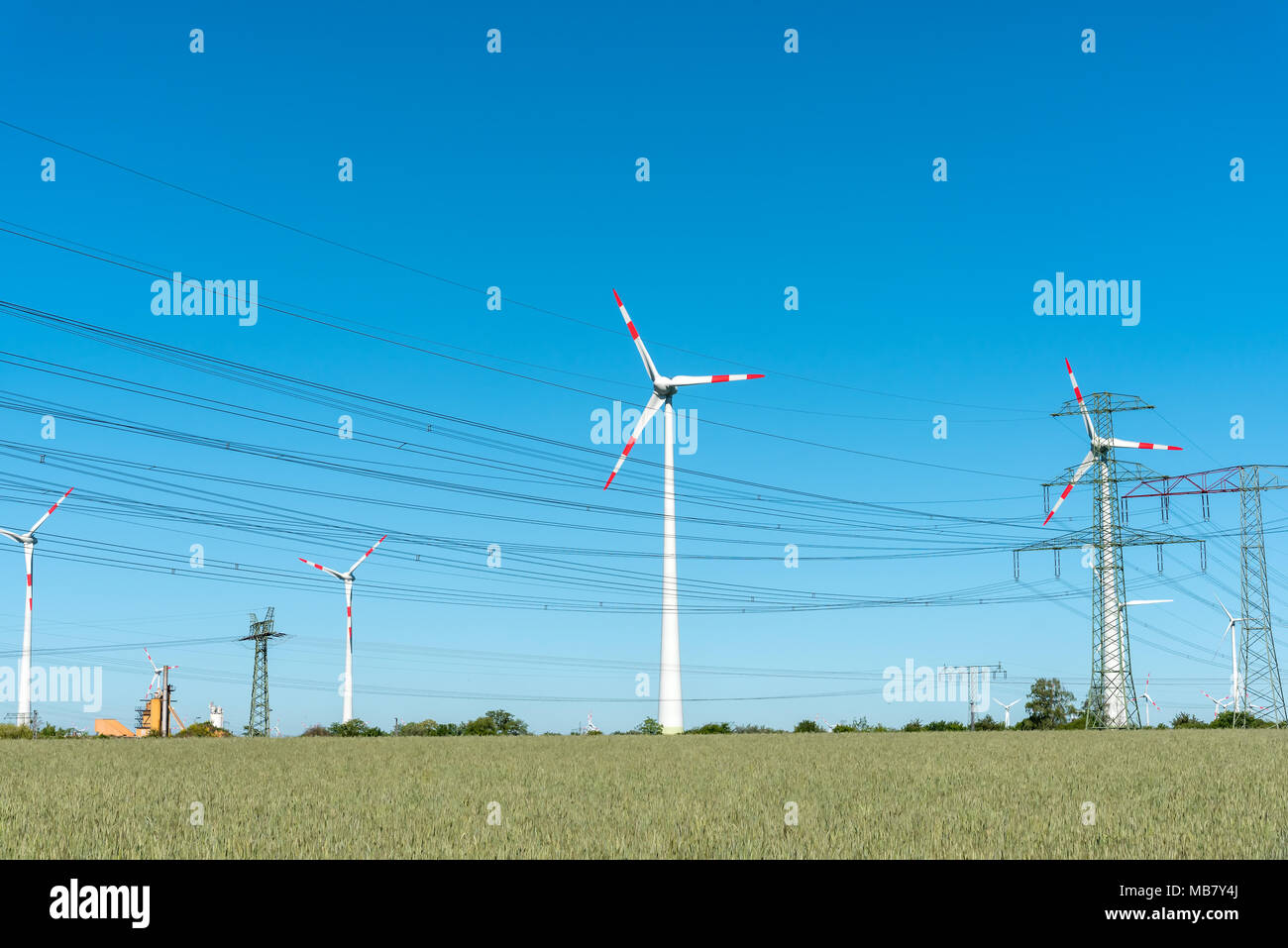 Wind Motoren und Versorgungsleitungen an einem sonnigen Tag in Deutschland gesehen Stockfoto