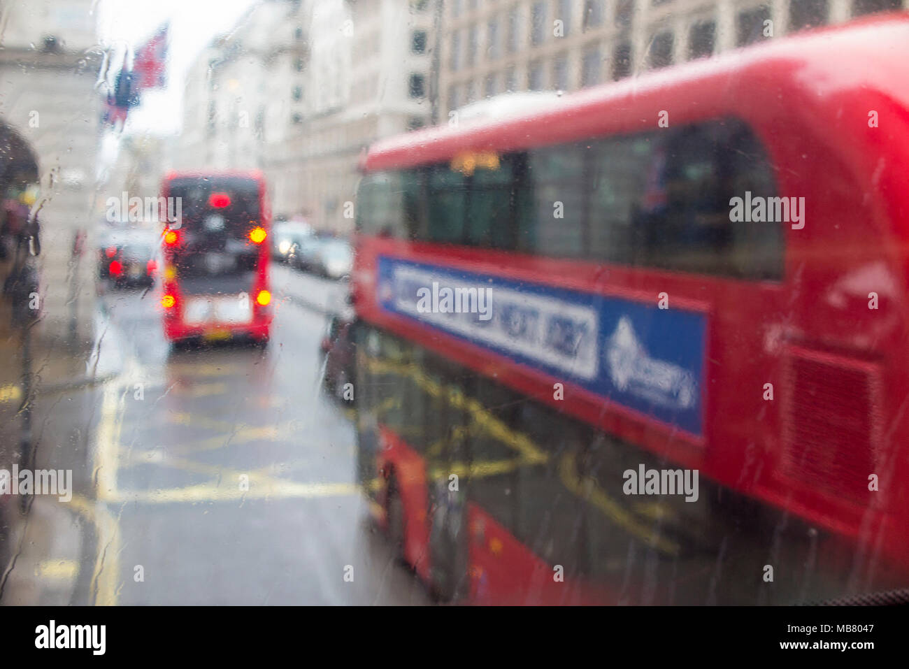 Ein Blick durch ein Regen fallen Fenster von Bussen auf der Piccadilly in London vom oberen Deck Stockfoto