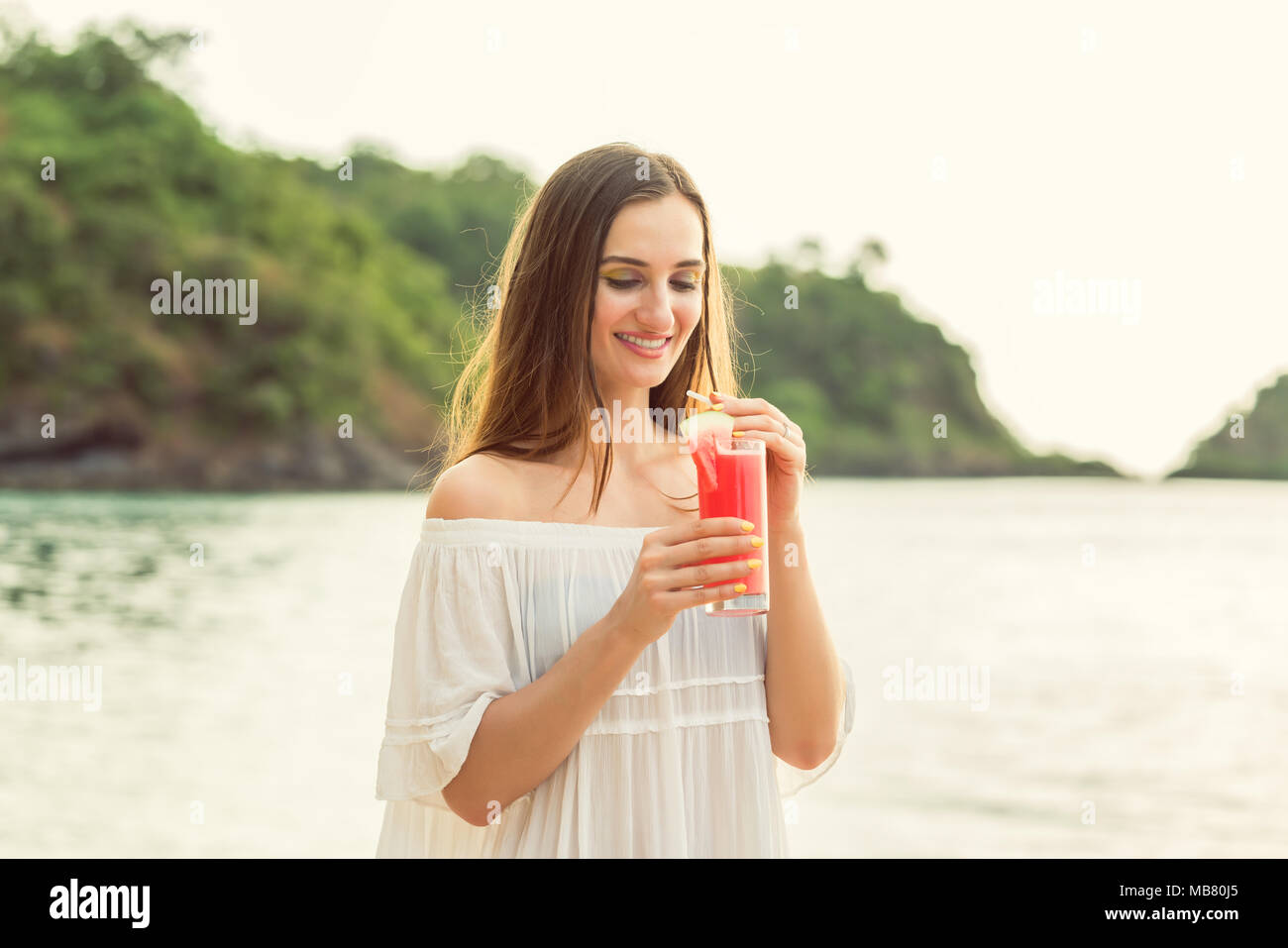 Porträt einer jungen Frau mit einem frische Wassermelone Cocktail auf tropischen Strand Stockfoto