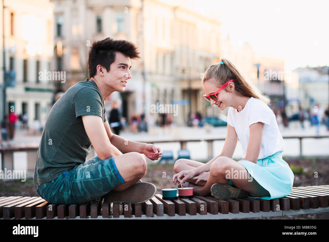 Junge Teenager Mädchen und Jungen die Zeit gemeinsam in der Innenstadt genießen Eis essen an einem Sommertag. Ausgaben an sonnigen Nachmittag Stockfoto