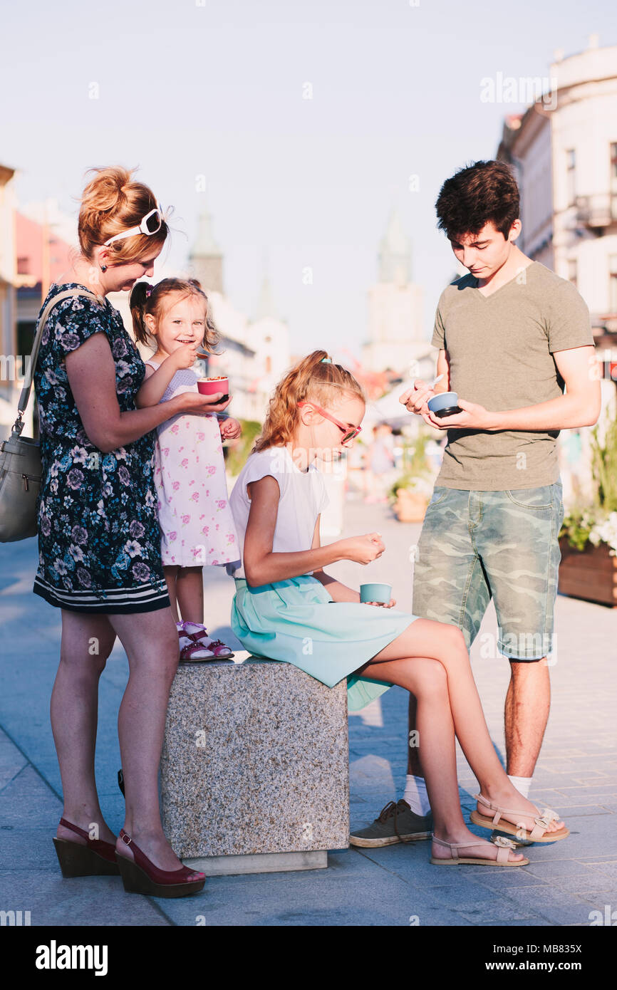 Familie die Zeit, die sie gemeinsam in der Innenstadt genießen Eis essen am Tag. Mutter, Kind und Teenager und junge Ausgaben Stockfoto