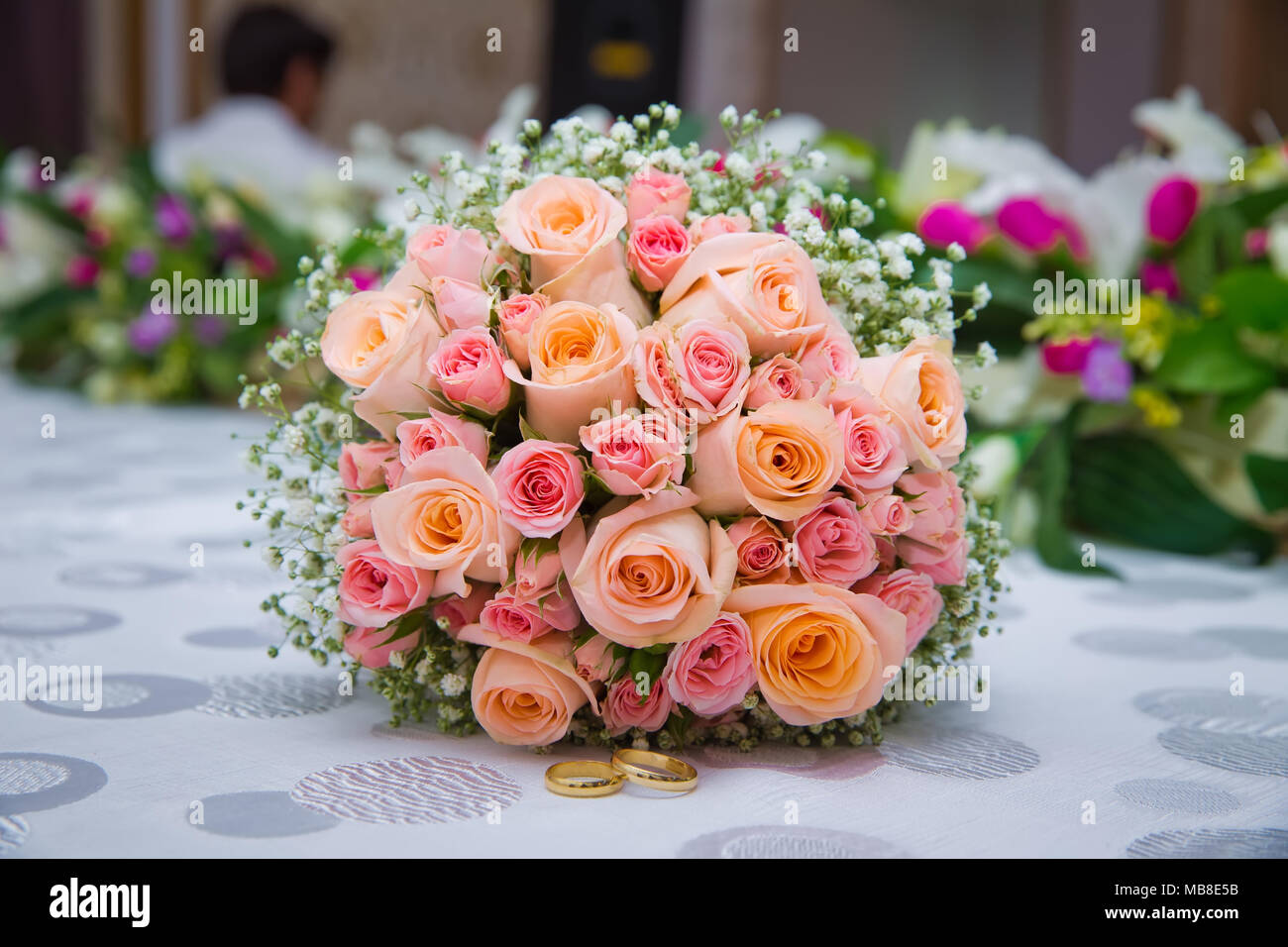 Brautstrauß mit orange und rosa Rosen unterschiedlicher Größe mit auf weißem Hintergrund Stockfotografie