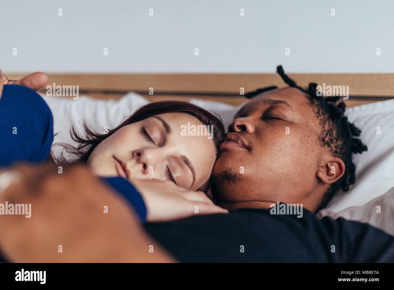 Mixed Race Paar zusammen schlafen im Bett. Afrikanischer Mann schlafen mit kaukasischen Frau zu Hause. Stockfoto