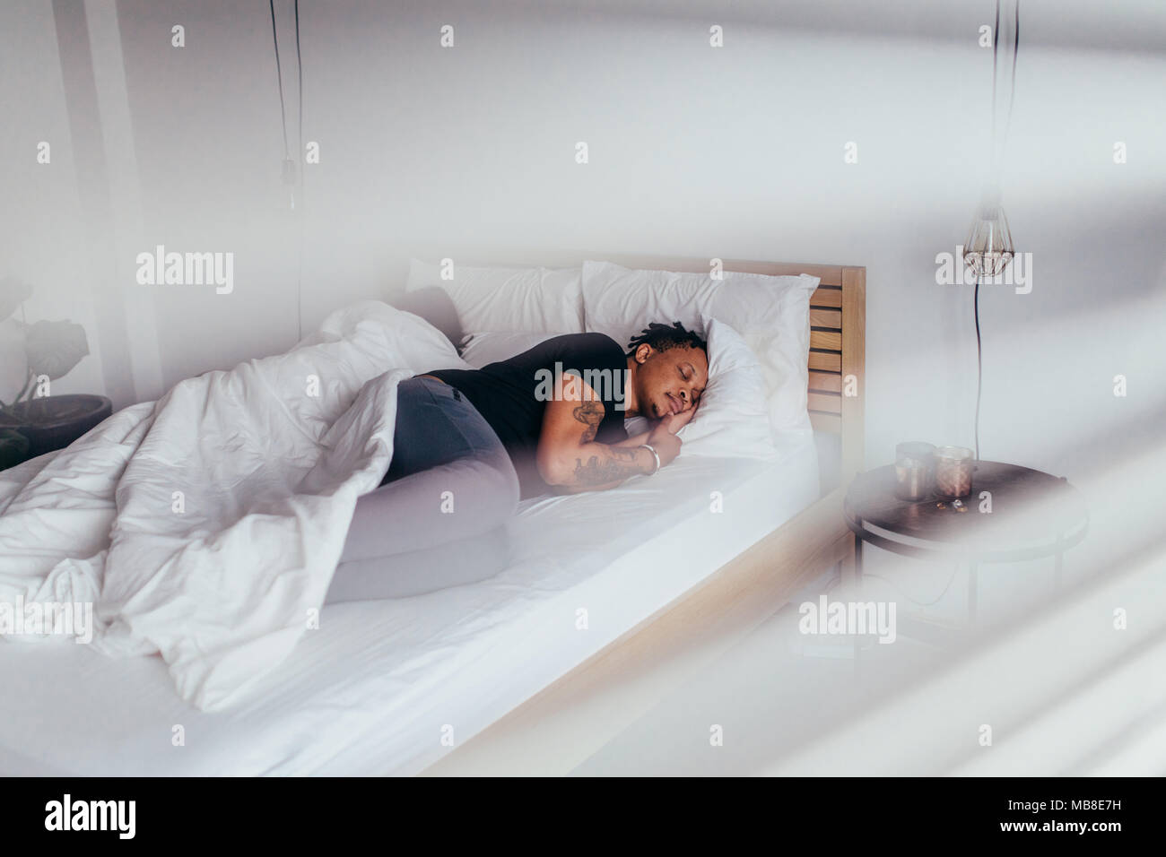 Afrikanischer Mann schlafen im Schlafzimmer der Frau zurück. Paar wieder Schlaf im Bett zurück. Stockfoto