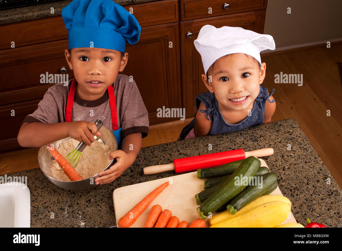 Geschwister Essen und Kochen in der Küche. Stockfoto