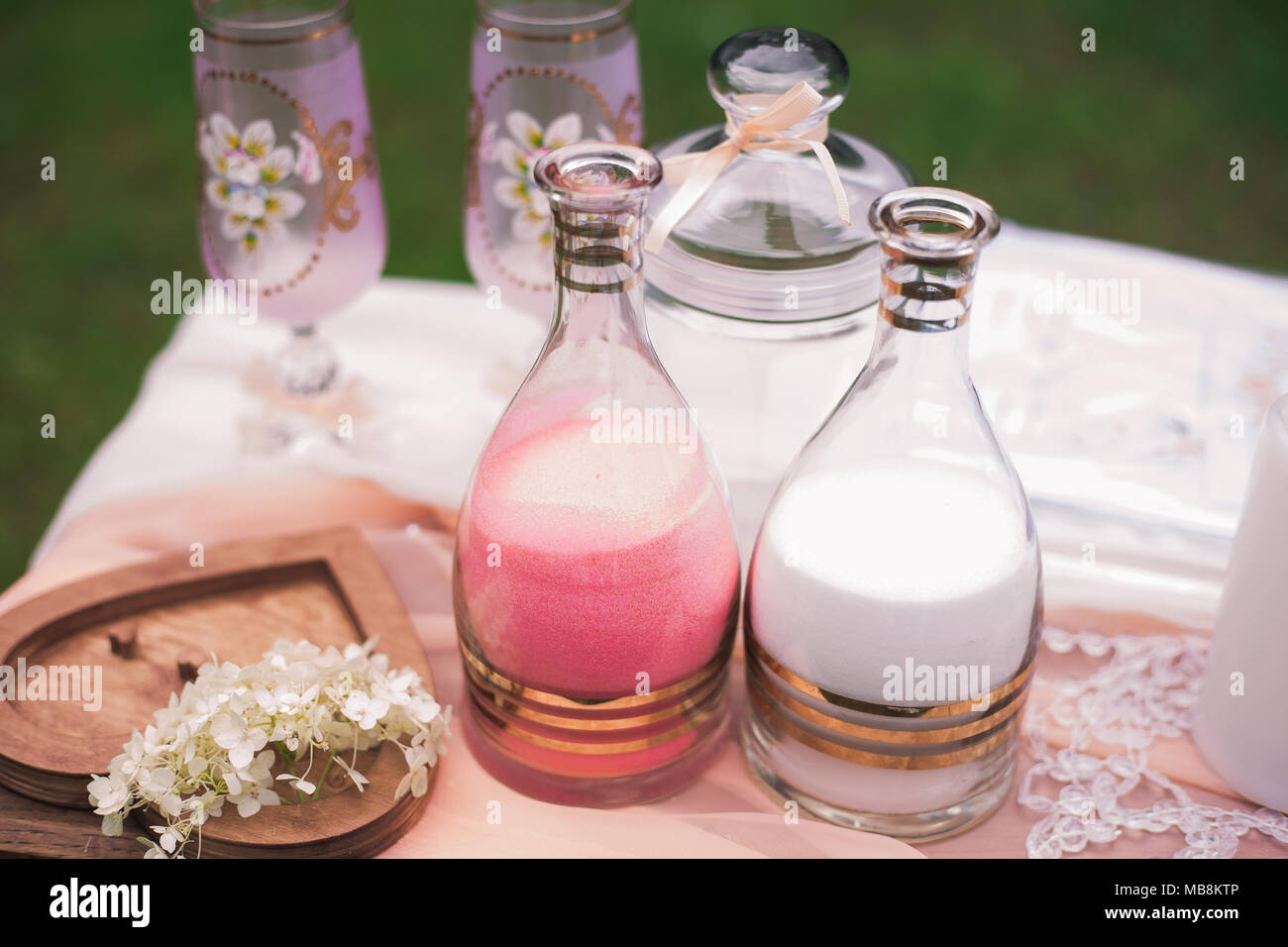 Detailansicht von Elementen der Hochzeit sand Zeremonie. Zwei Flaschen mit dekorativen rosa und weiße Farbe sand bereit für das Gießen in einer Vase als Symbol der un Stockfoto