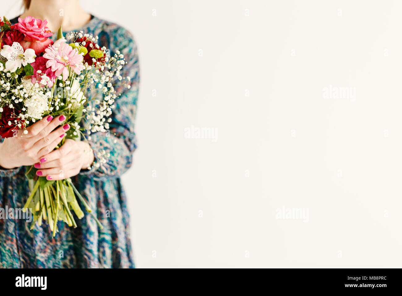 Frau mit Frühling Blumen stehend gegen weißen Hintergrund mit Kopie Raum Stockfoto