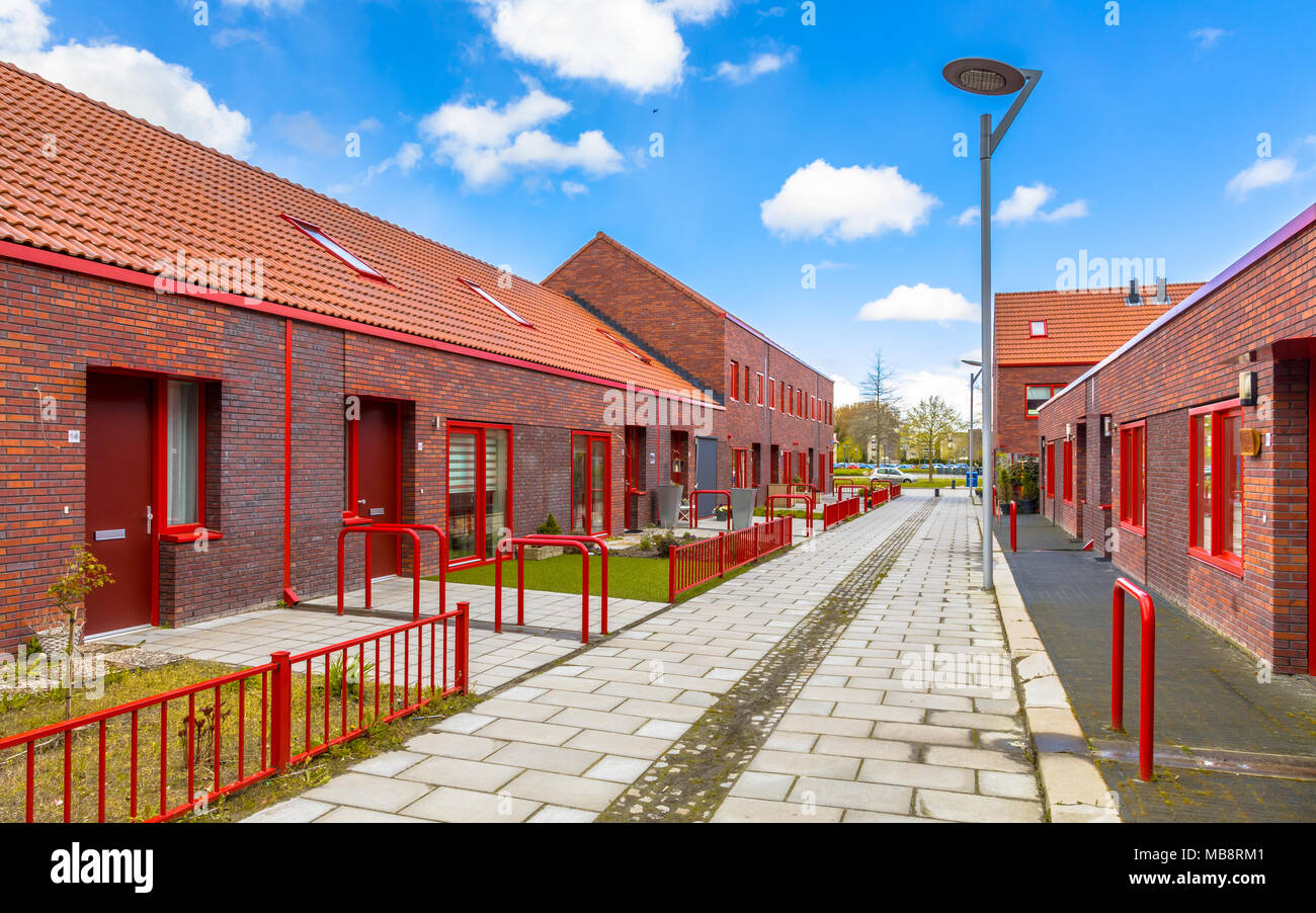 Moderne Gegend mit braunen Backsteinhäusern und roten Elementen. Stockfoto