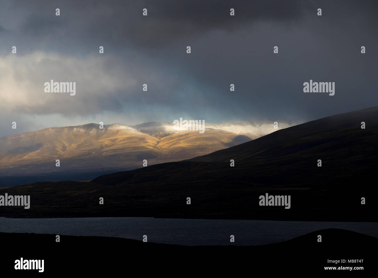 Dunklen Himmel und schneebedeckten Bergen an der Grenze von Torres del Paine National Park mit See Sarmiento im Vordergrund, Chile. Stockfoto