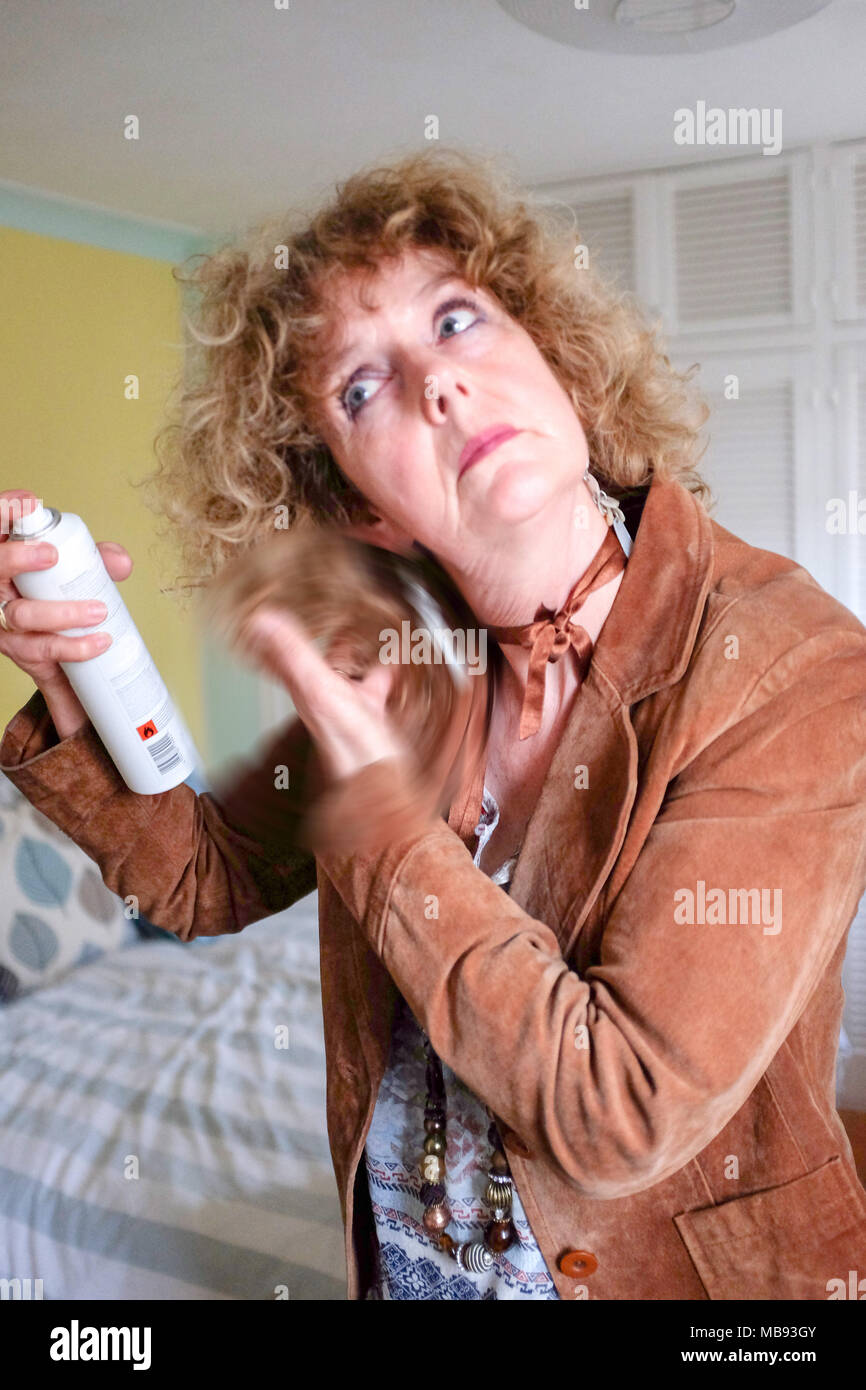 Reife Frau mittleren Alters mit Haarspray auf die markierten blondes lockiges Haar bereit für Asche Abend Foto aufgenommen von Simon Dack Stockfoto